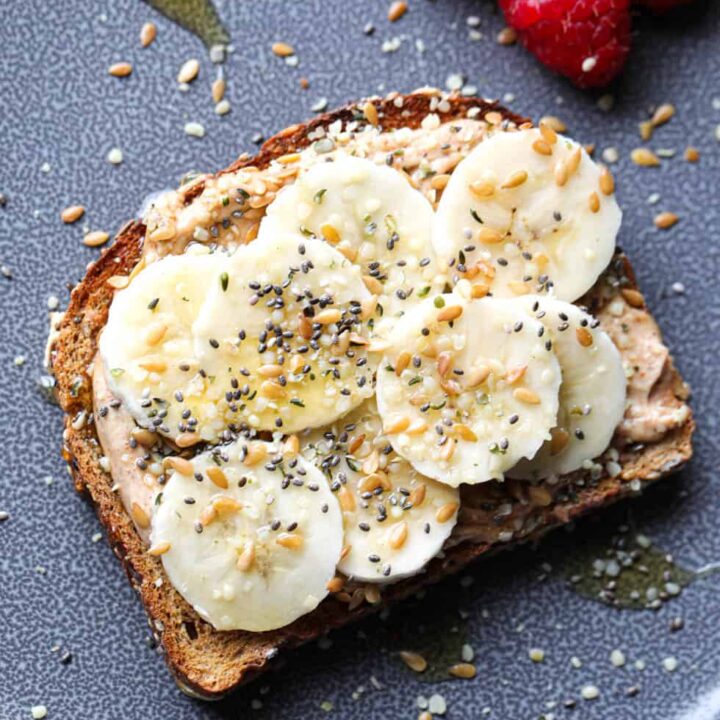 High protein peanut butter banana toast topped with hemp, chia, and flax seeds
