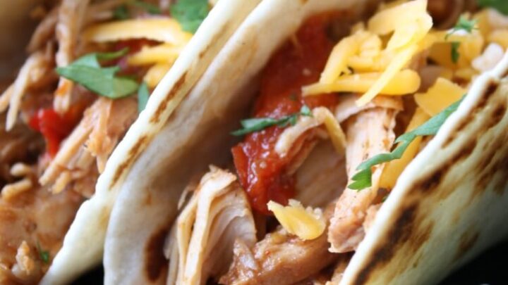This Slow Cooker Chicken Tacos recipe is full of tender shredded chicken, peppers, and onions all slow cooked in salsa for a flavorful easy dinner.