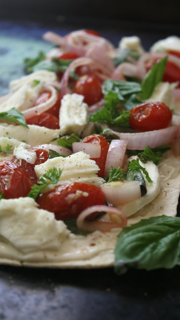 Loaded with flavor this Thin Crust Caprese Pizza combines Basil, Mozzarella, and Sauteed tomatoes with a Tangy Aioli as the sauce. 
