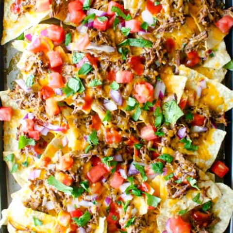 Slow Cooked Beef Barbacoa over a plate of nachos