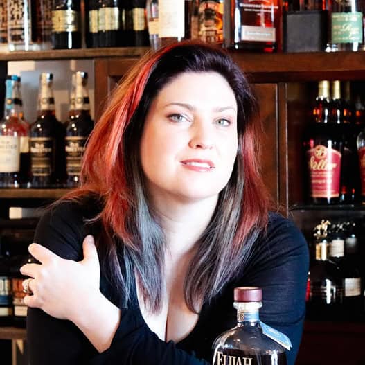 A picture of a woman sitting in front of a bar. 