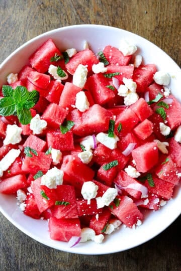 A bowl of watermelon salad with feta cheese and mint.