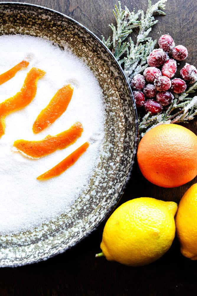 Fresh citrus slices covered with sugar, garnished with seasonal berries and lemons for holiday treats.