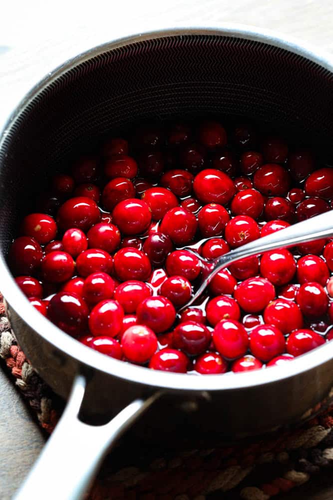 Cranberries being soaked in a simple syrup 