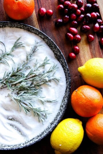 Bright lemons and oranges with cranberries and sugared rosemary sprigs.