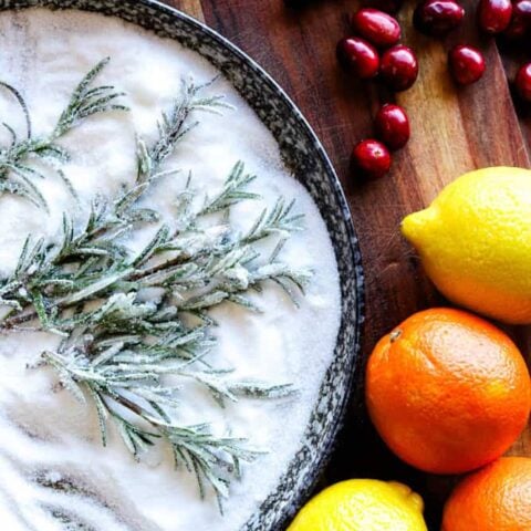 Bright lemons and oranges with cranberries and sugared rosemary sprigs.