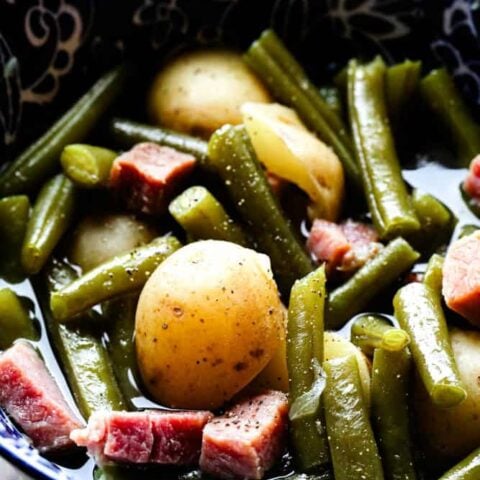 Crock pot ham, green beans, and potatoes served in a bowl with tender ham and fresh green beans
